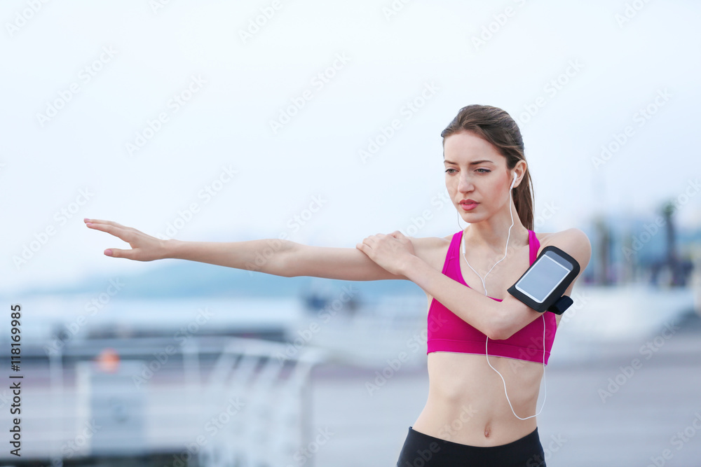 Young woman doing exercises on pier