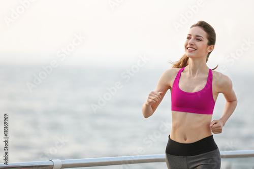Young woman running on pier