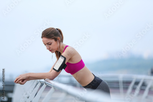 Young woman in sportswear standing on pier