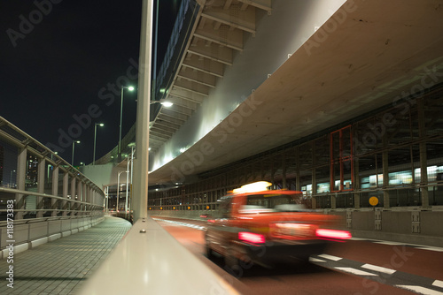 Motion blurred red taxi on Rainbow Bridge in Tokyo at night photo