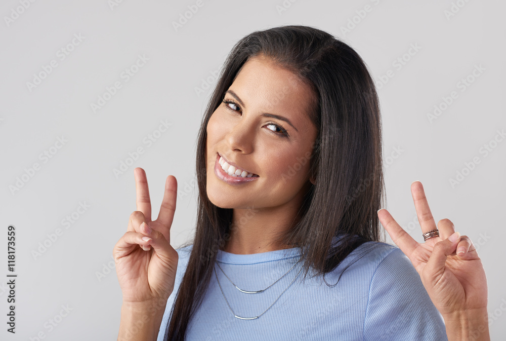 Cute young mixed race woman making peace sign with her hands Cute young mixed race woman making peace sign with her hands
