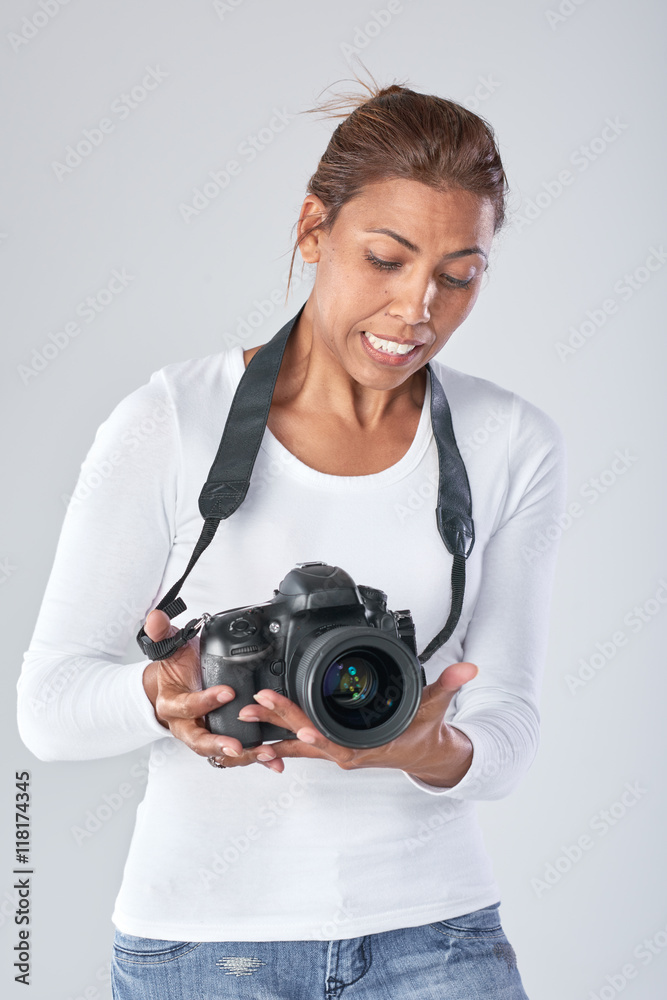 Woman holding camera, looking unsure Woman holding camera, looking unsure