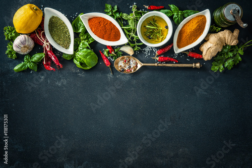 Herbs and spices over black stone background