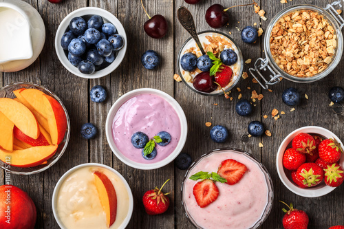 Homemade yogurt with fresh strawberry, blueberry, peach on a woo