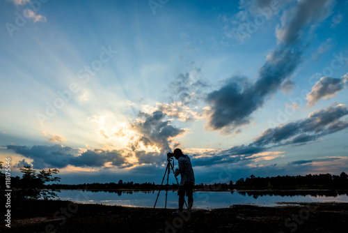 Silhouette photographer on sunset background