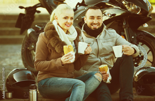 Cheerful smiling couple having picnic with coffee
