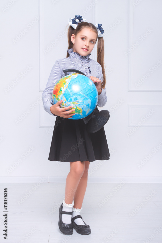 Fototapeta premium Girl standing with a globe and smiling