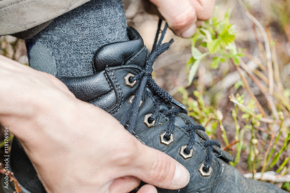 a tourist laces his hiking boots