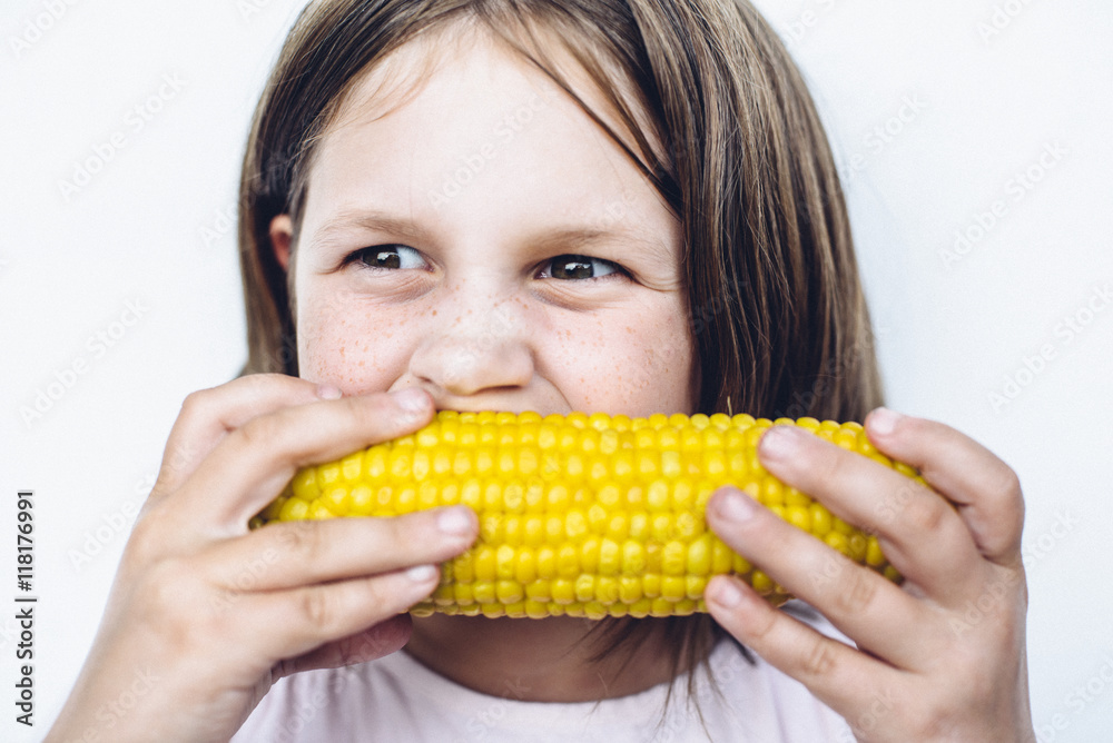 Preteen girl eating sweet corn Preteen girl eating sweet corn