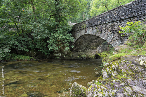 Great Langdale beck flows under Elterwater bridge. Elterwater is a popular meeting point for walkers and tourists exploring Great Langdale in the Lake District National Park, Cumbria, England. photo