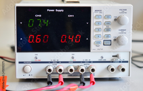 A white power supply with black display on a desk
