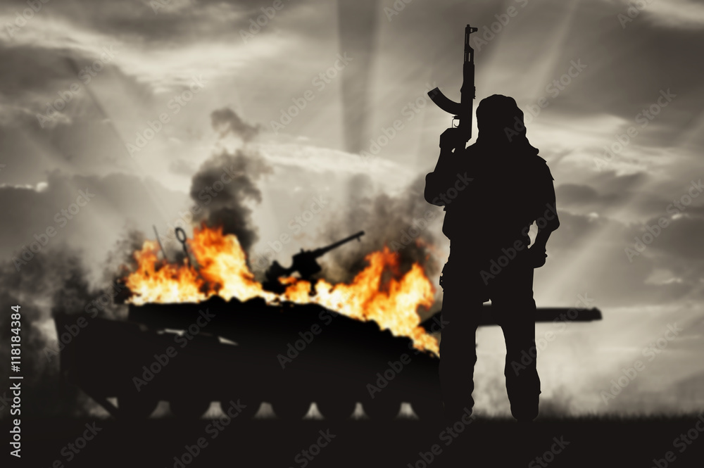 Silhouette of terrorist holding rifle against burning tank - obrazy, fototapety, plakaty 