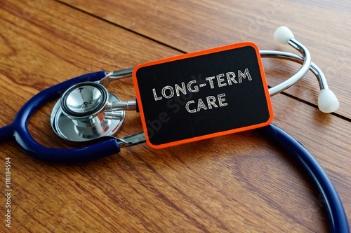 Medical concept.Word LONG-TERM CARE with stethoscope on wooden table.