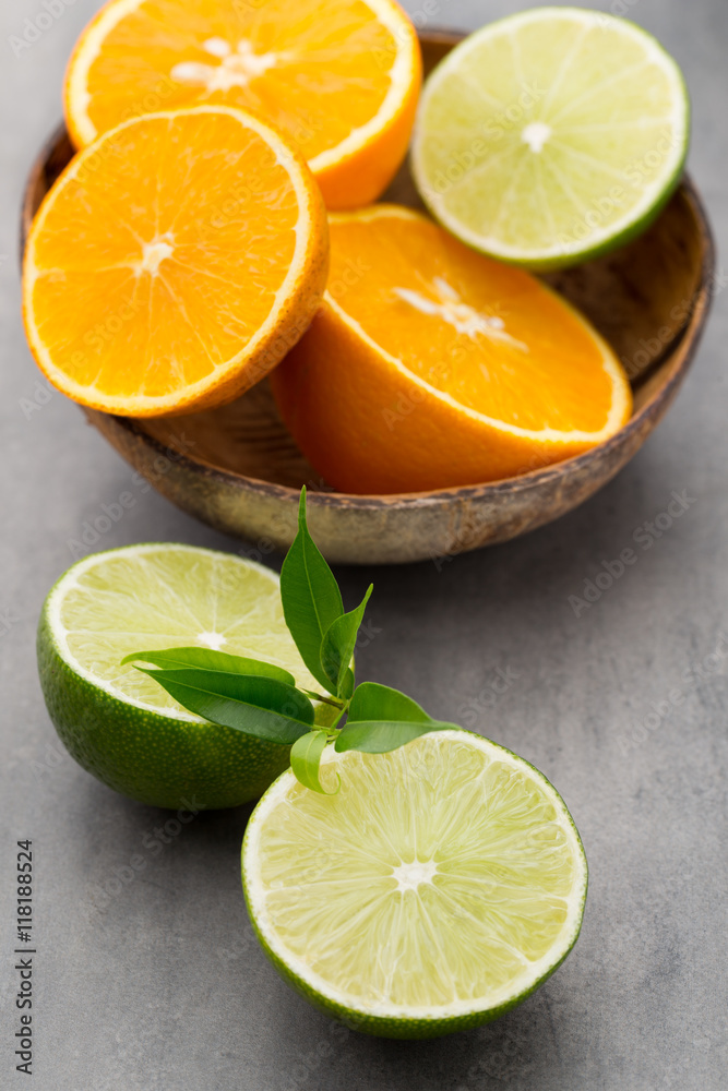 Mixed citrus fruit lemons, orange, kiwi, limes on a gray backgro Mixed citrus fruit lemons, orange, kiwi, limes on a gray backgro