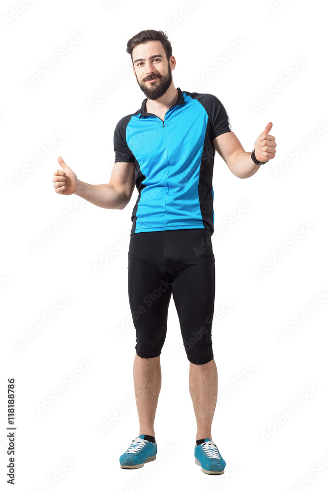 Happy successful sports cyclist in blue jersey showing thumbs up hand gesture. Full body length portrait isolated over white studio background. Happy successful sports cyclist in blue jersey showing thumbs up hand gesture. Full body length portrait isolated over white studio background.