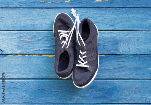 Blue sneakers hang on nail 