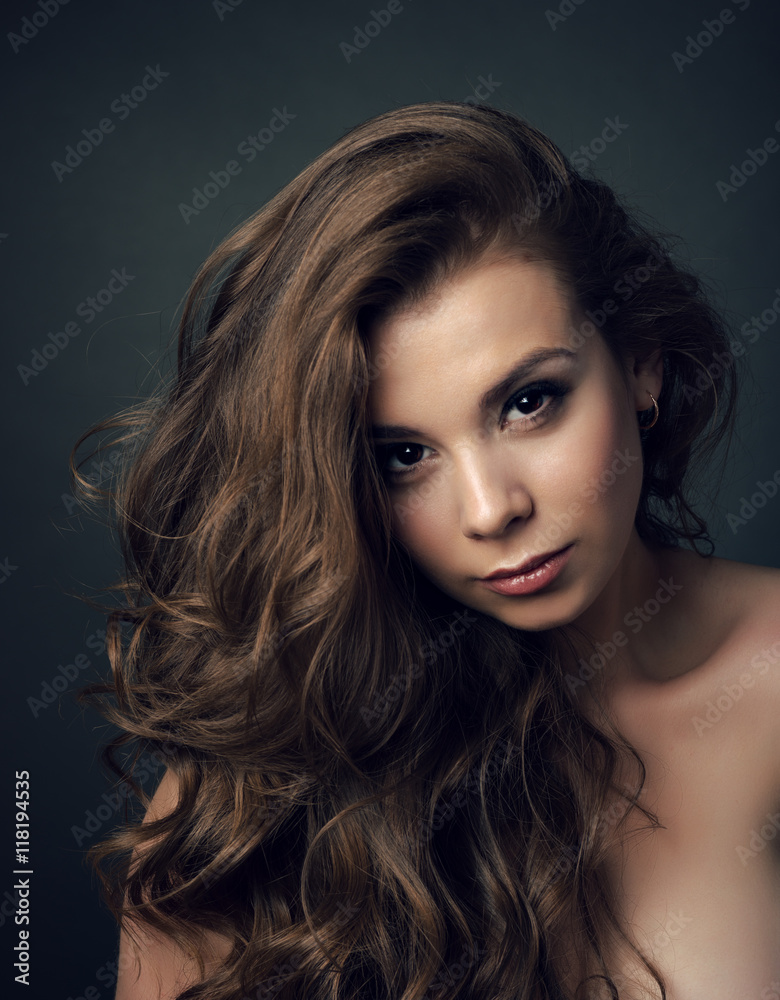 Fototapeta premium Portrait of a young beautiful brunette girl with long hair