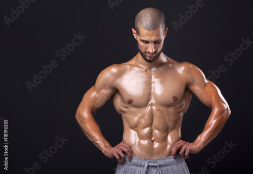 Bodybuilder posing on black background