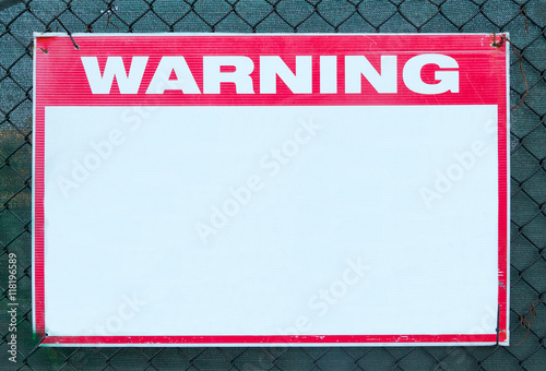 Warning Sign safety caution with blank white message at construction site grid boundary.