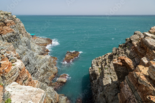 View of steep and rocky cliff, little cove and ocean at the Taejongdae Resort Park in Busan, South Korea.