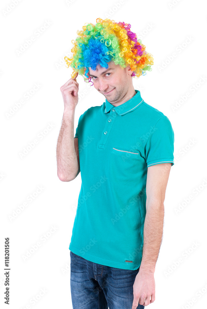 Portrait of a man in a clown wig. guy silly smiles. Isolated over white background The clown in colored wig looks shyly into the frame. Portrait of a man in a clown wig. guy silly smiles. Isolated over white background The clown in colored wig looks shyly into the frame.