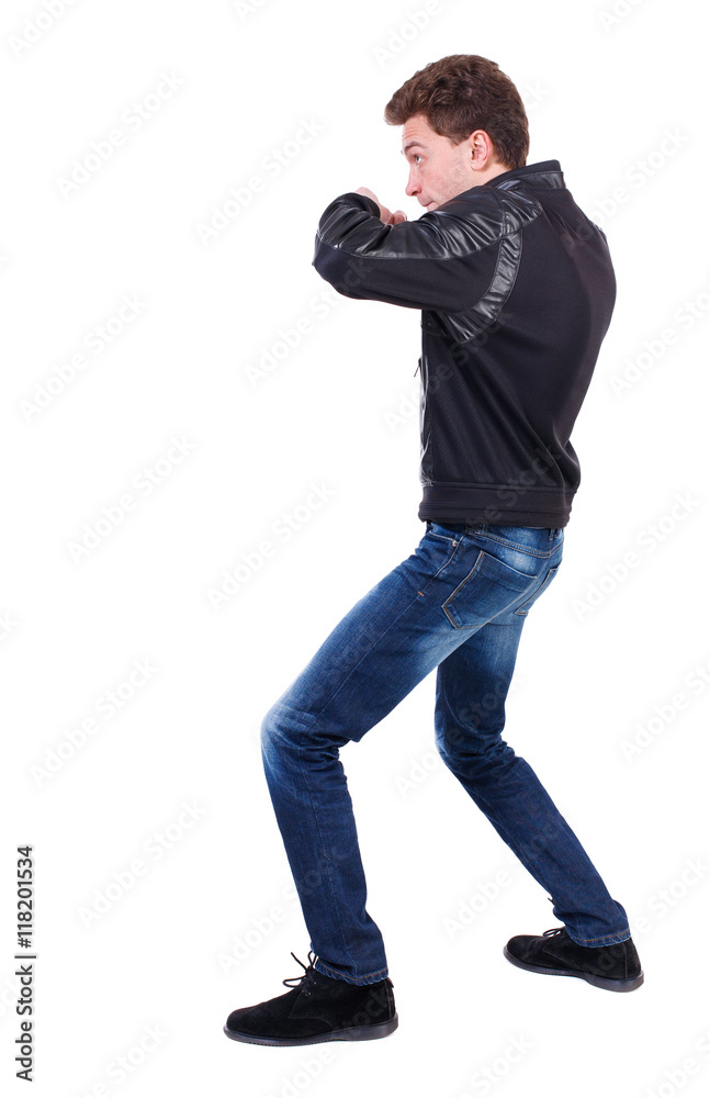 back view of guy funny fights waving his arms and legs. Isolated over white background. Rear view people collection.  backside view of person.  Curly guy in a black leather jacket fights waving his