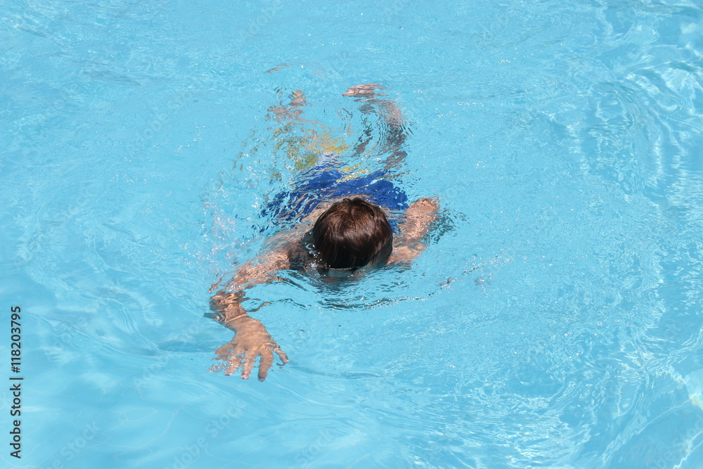  A young boy swimming in a pool while on vacation, 2016 