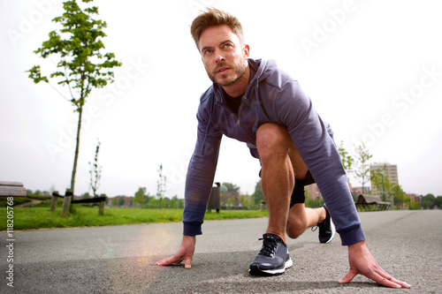 Male runner training in starting position