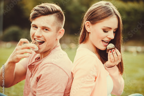 Lovely couple eating cupcakes.