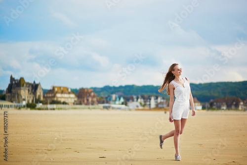 Beautiful young woman enjoying sun on a sand beach © Ekaterina Pokrovsky