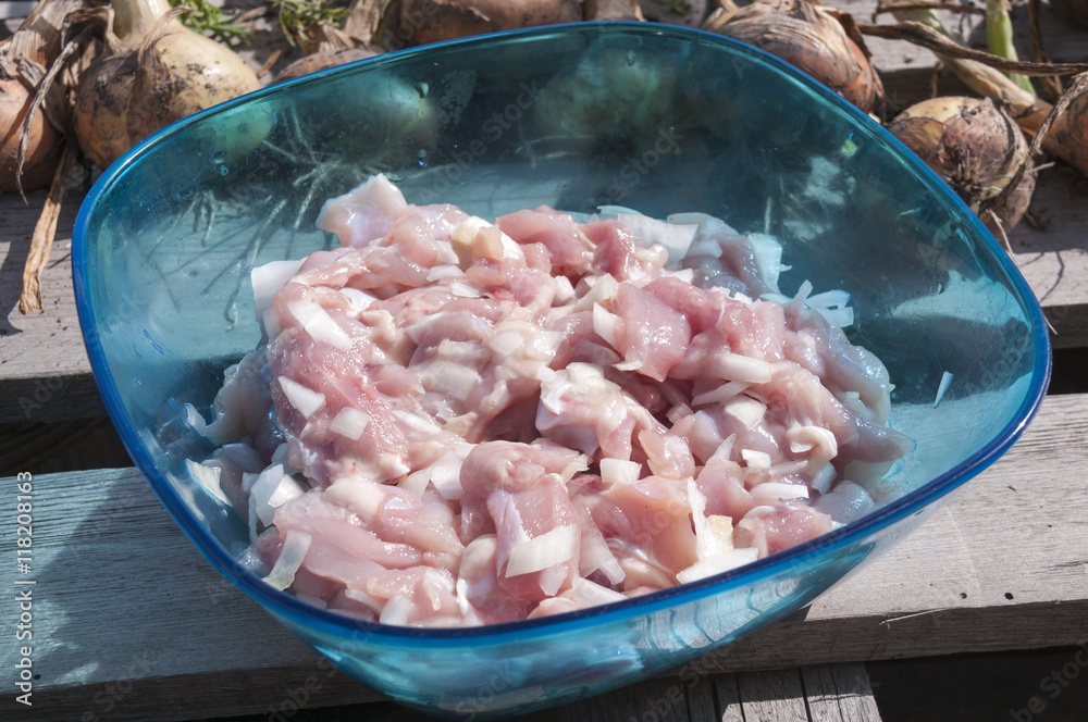 A plate of raw chicken meat with onion A plate of raw chicken meat with onion