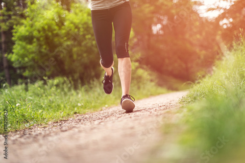Woman running in the forest. Close up on woman legs. Active and fit.