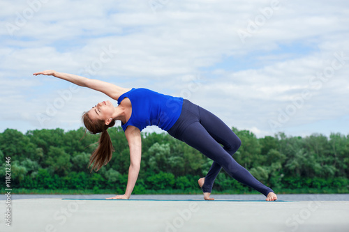Young woman doing yoga exercise on mat02 © serguastock
