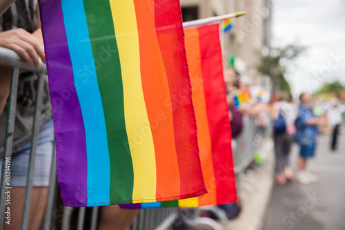 Gay rainbow flags at Montreal gay pride parade with blurred spectators in background