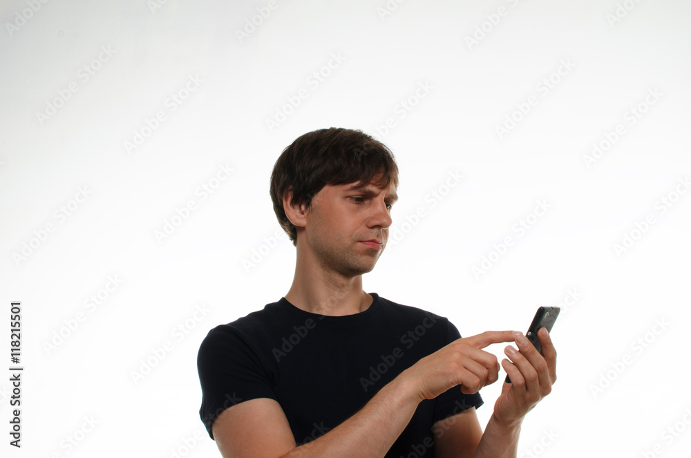 Close up portrait of european man in black t-shirt on neutral white background write message by black mobile or have chat, serf internet and thinking. Communication concept. Close up portrait of european man in black t-shirt on neutral white background write message by black mobile or have chat, serf internet and thinking. Communication concept.