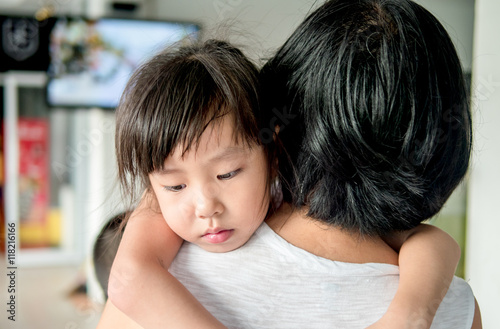 Asian baby girl hugging her mother , sleepy