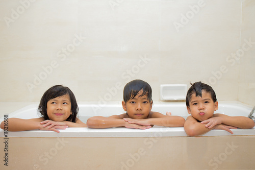 3 relatives Asian children play and take a bath in bathtub