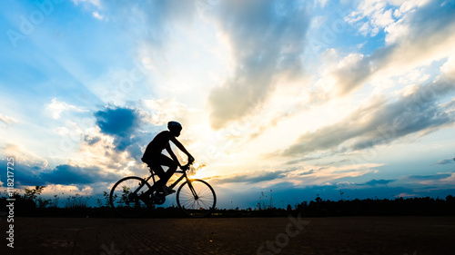 Silhouette of cyclist motion on sunset background