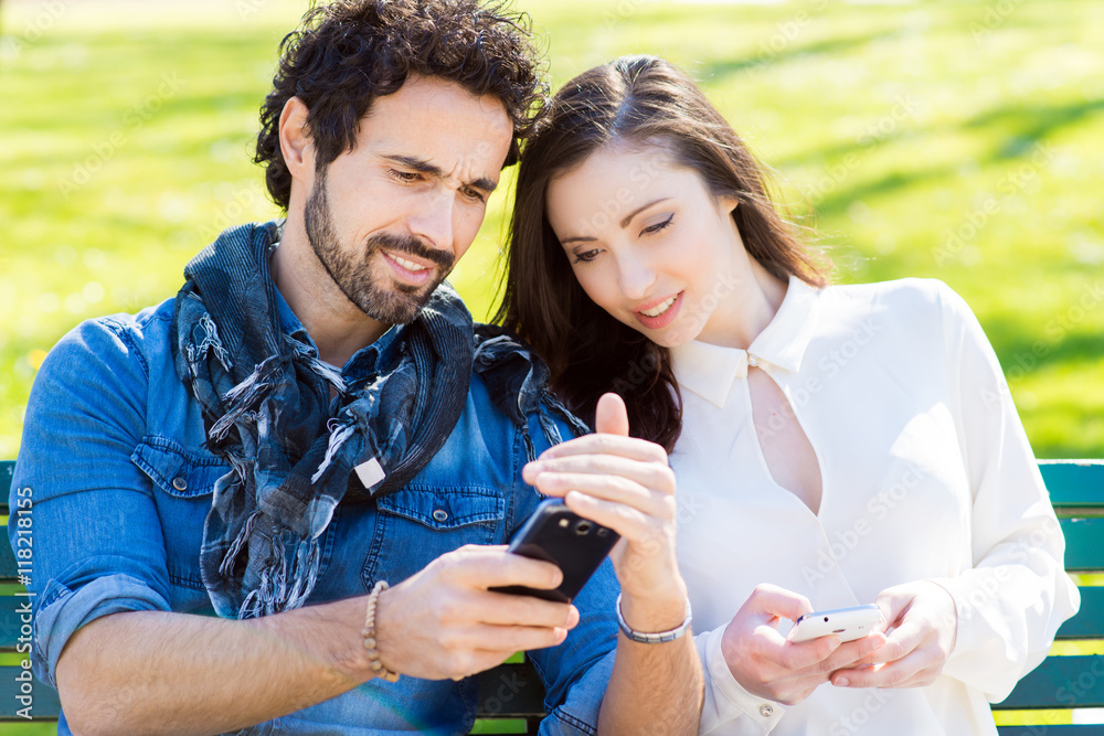 Smiling man showing his mobile phone to a girl Smiling man showing his mobile phone to a girl