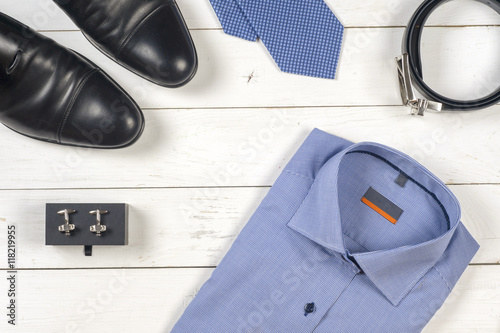 set of men's clothing and shoes on wooden background.