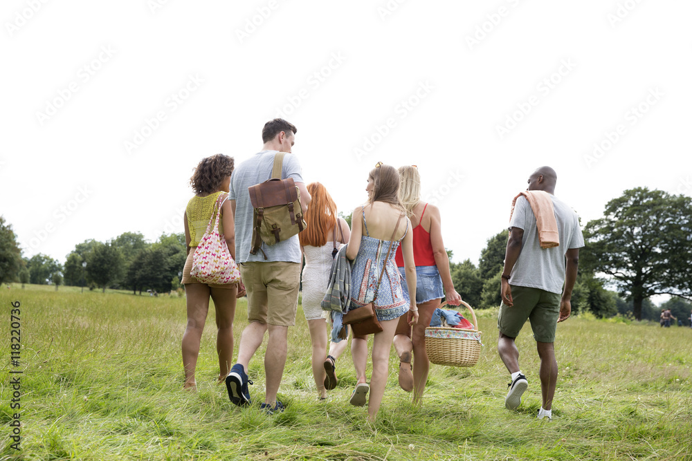Rear View Of Young Friends Going For Countryside Picnic Rear View Of Young Friends Going For Countryside Picnic