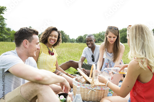 Group Of Friends Sitting On Blanket Enjoying Picnic 