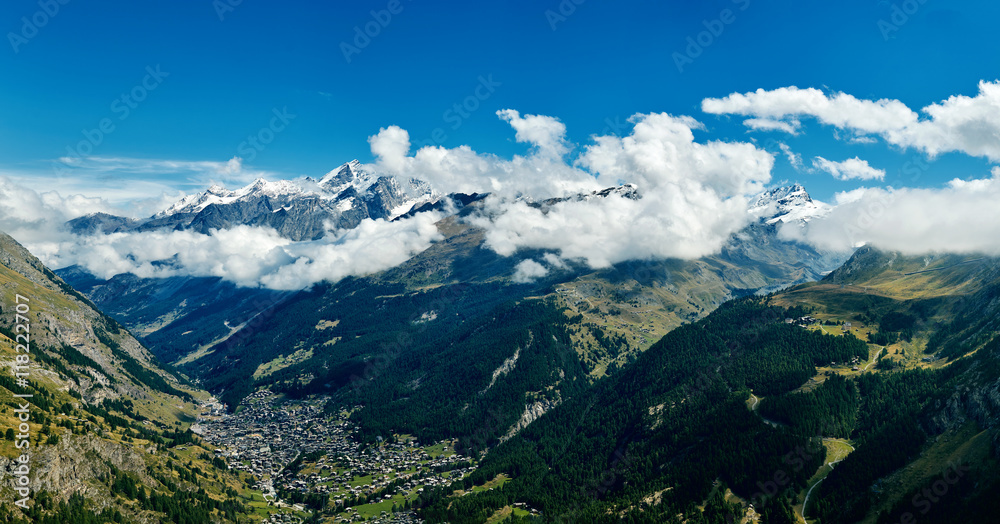 Snow capped alpine mountains and valley with Zermatt town. Trek near Matterhorn mount.