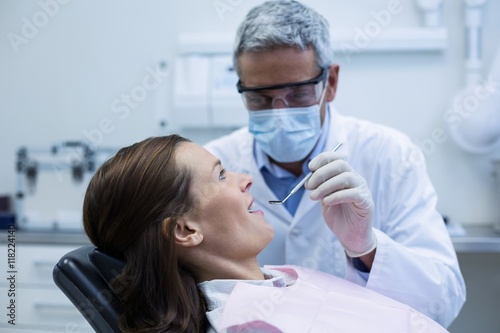 Fototapeta Naklejka Na Ścianę i Meble -  Dentist examining a young patient with tools