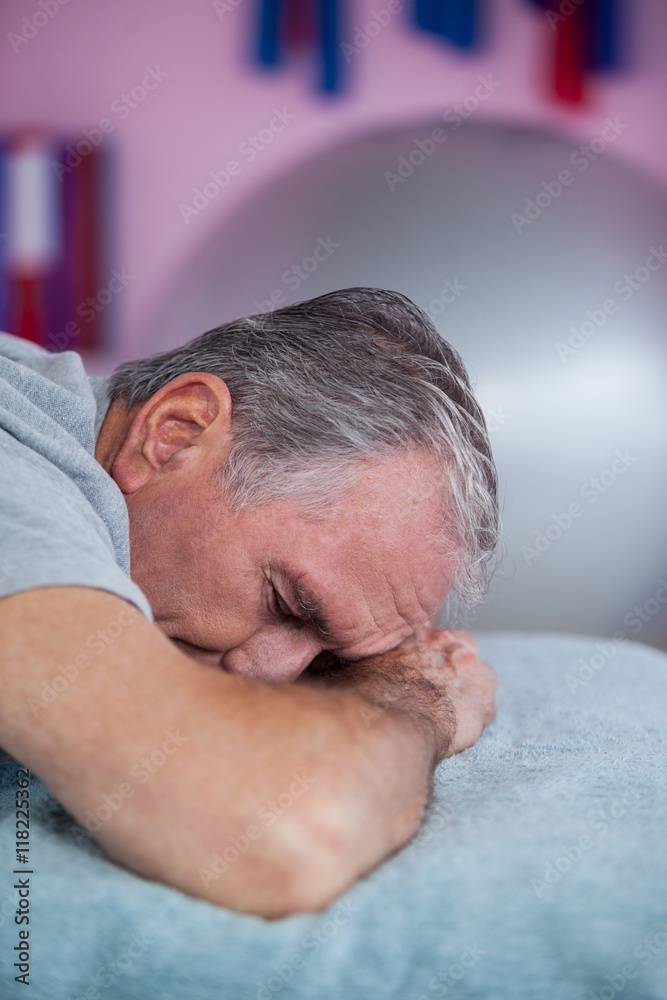 Obraz premium Senior man lying on a massage bed