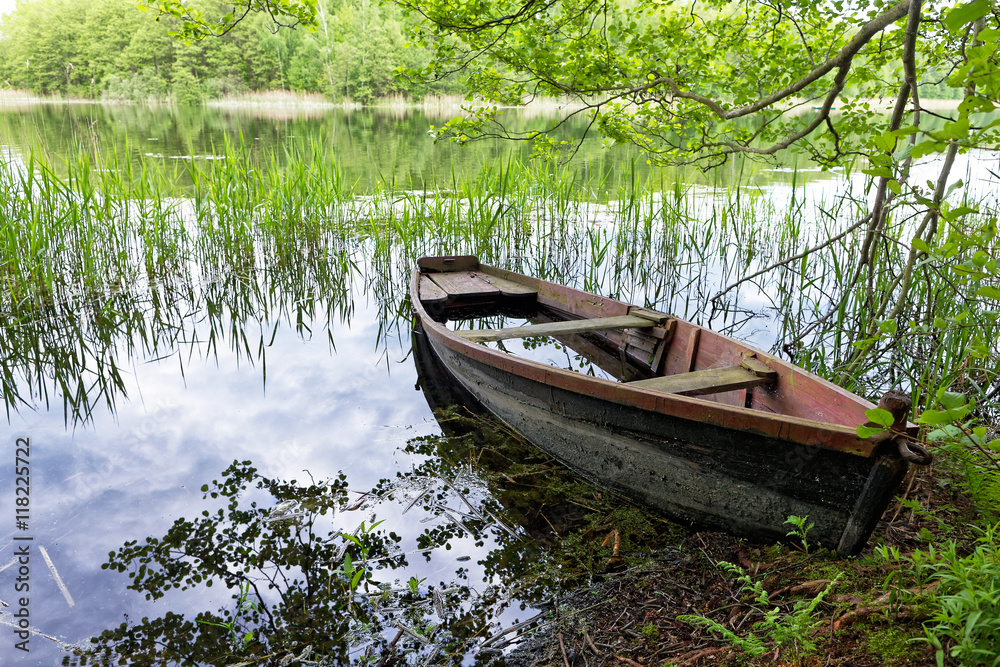 Abandoned wooden fishing boat at lake shore Abandoned wooden fishing boat at lake shore