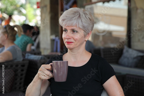 Woman in cafe drinking coffee or tea