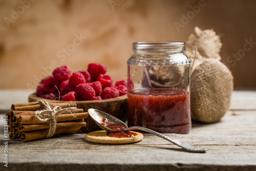 Rasberry jam with cinnamon on rustic background