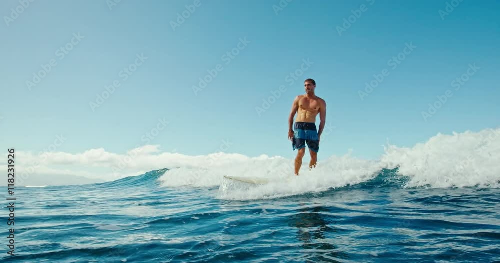Young man having fun surfing, riding ocean wave in slow motion Young man having fun surfing, riding ocean wave in slow motion