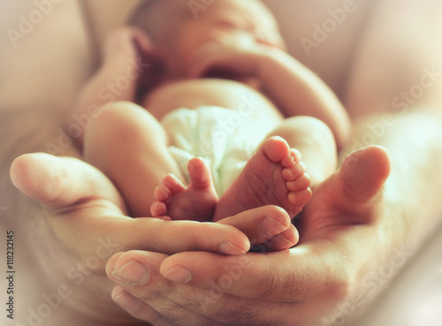 sleeping newborn baby on male hands photo